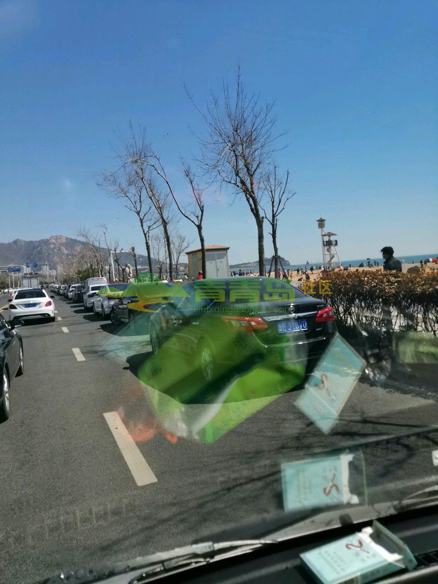 东海东路石老人海水浴场道路上停满违停车辆,造成周边道路堵车严